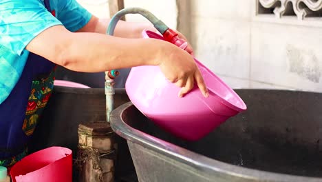 person washing with pink basin in bangkok