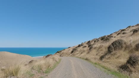 Pov-Off-road-Ciclismo-Cuesta-Abajo-Hacia-Una-Hermosa-Vista-Al-Mar-En-Verano---Bossu-Road,-Canterbury