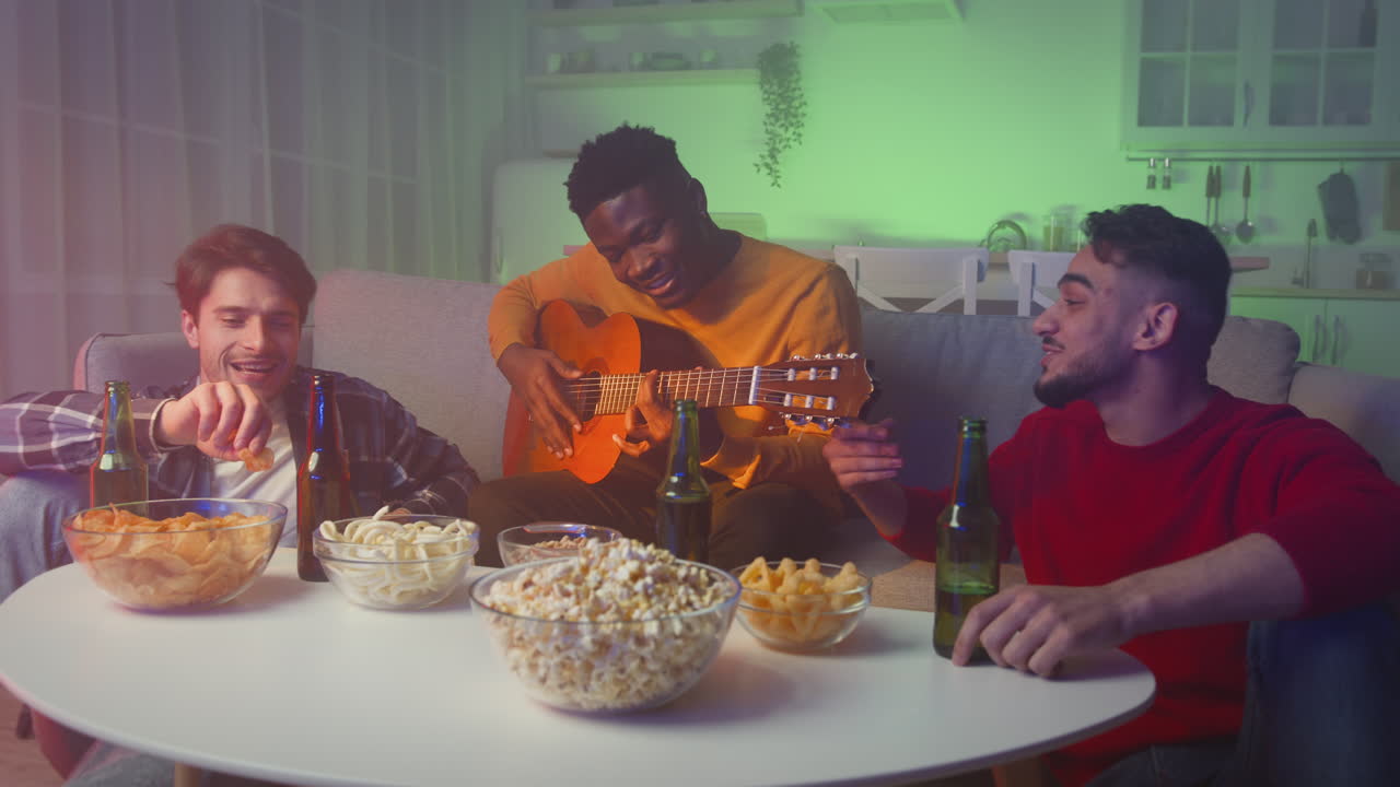 Friends having fun with music and snacks at home