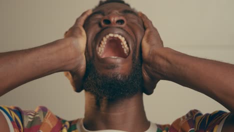 Depressed-Frustrated-Bearded-Young-Afro-American-Man-Holding-Head-With-Hands-And-Crying