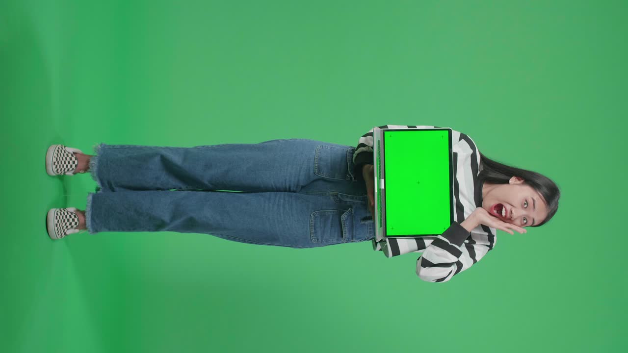 mujer sosteniendo una computadora portátil con pantalla verde