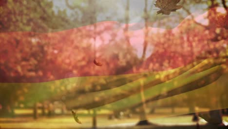 digital composition of germany waving flag over multiple autumn leaves falling against park