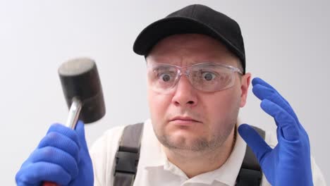 portrait of a builder hitting the camera with a hammer portrait of a builder hitting the camera with a hammer home renovation concept construction industry