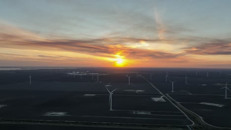 aerial view of wind farm and sunset in the background