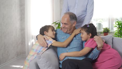 una foto de familia feliz. los nietos abrazan a su abuelo triste.