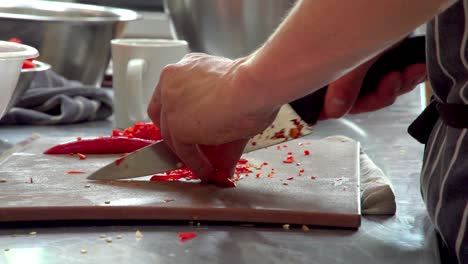 A-professional-chef-chopping-up-chilli-peppers