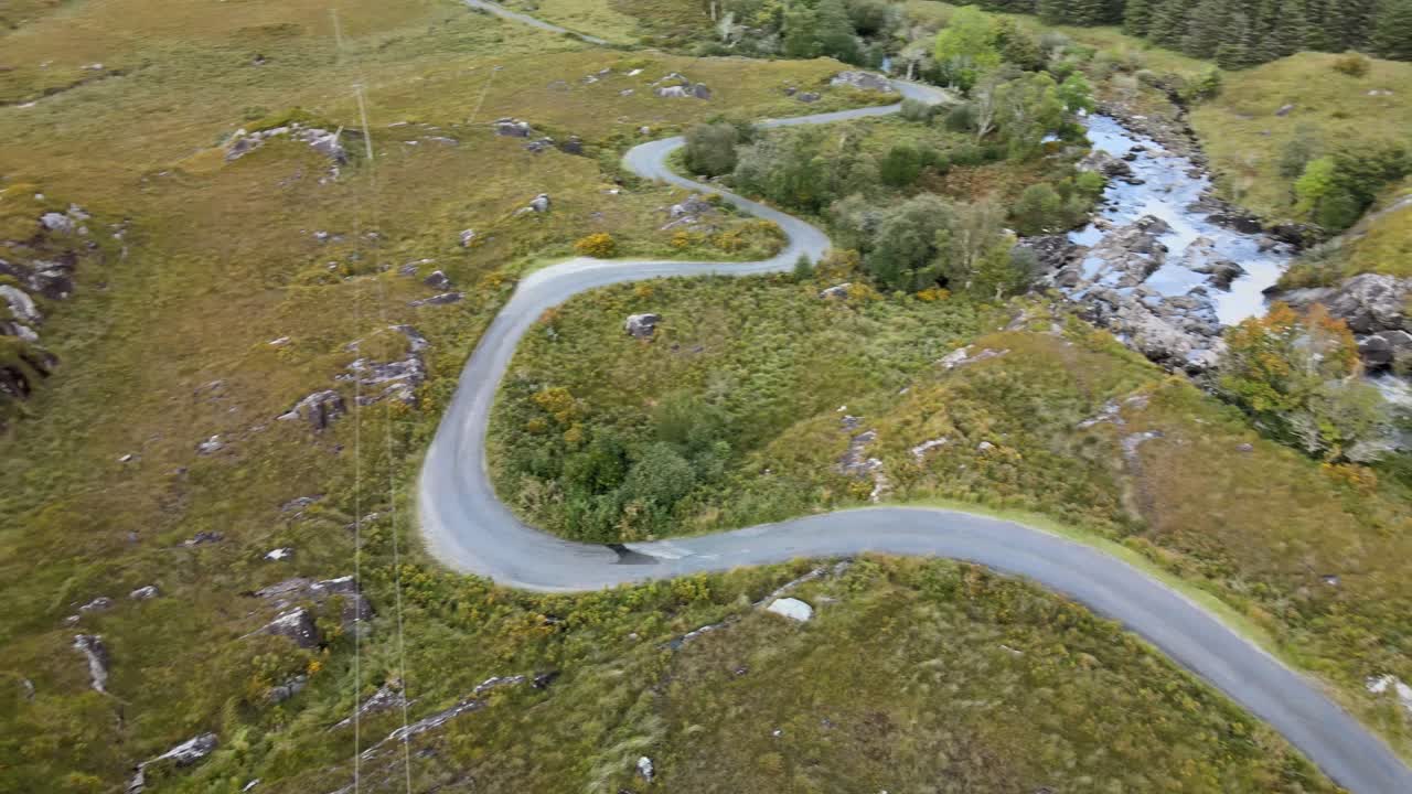 camino sinuoso y río que fluye en el paisaje otoñal en la irlanda salvaje