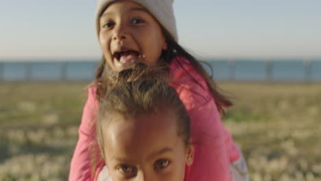 close-up-portrait-of-little-mixed-race-girls-enjoying-playing-games-looking-at-camera-happy-cheerful-seaside-park