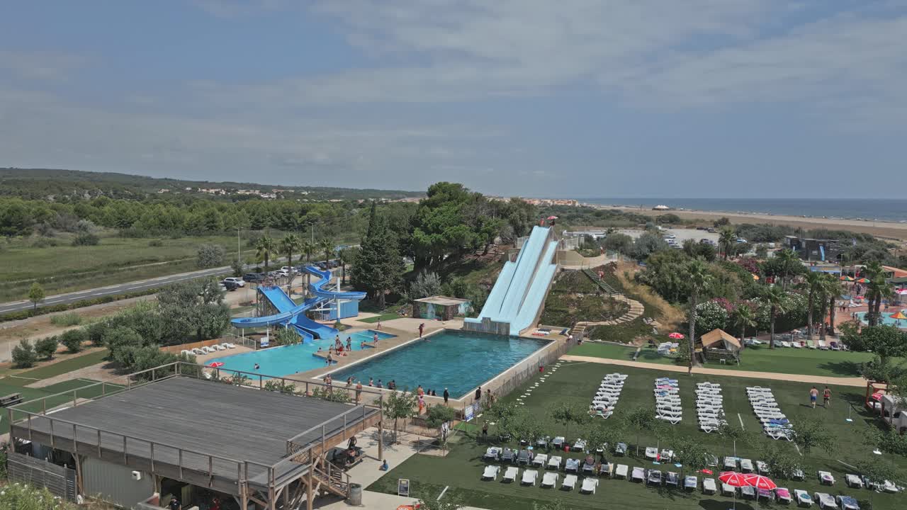 Tourists are enjoying their summer vacation sliding down water slides and splashing into a pool at a waterpark near narbonne, france