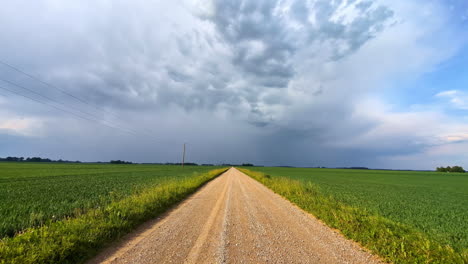 road rural field, grass growing both sides, dramatic skyline clouds