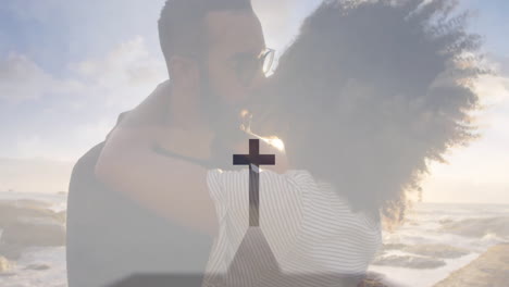 embracing couple on beach with cross symbol and animation overlay