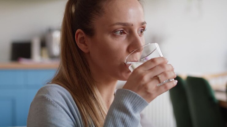 Pregnant woman taking vitamins at home
