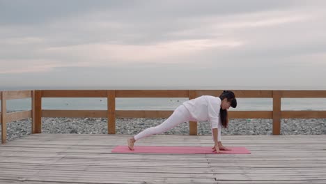 woman practicing yoga on a beach