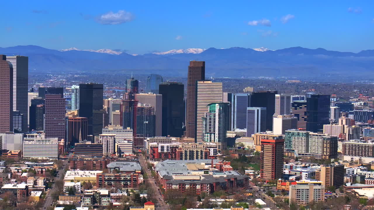 Indian Peaks City Park Lodo Downtown Denver Cityscape Landscape Colorado aerial drone view tall skyscraper buildings city living apartments spring summer front range mountains pan left motion