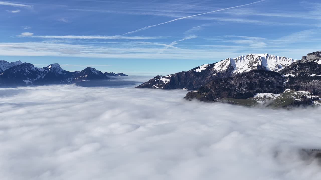 Une mer de brouillard dense (Nebelmeer) avec les Alpes suisses enneigées entourant Amden, Walensee, Suisse. Paysage ensoleillé et serein de haute altitude véhiculant des concepts de paix et d’évasion.