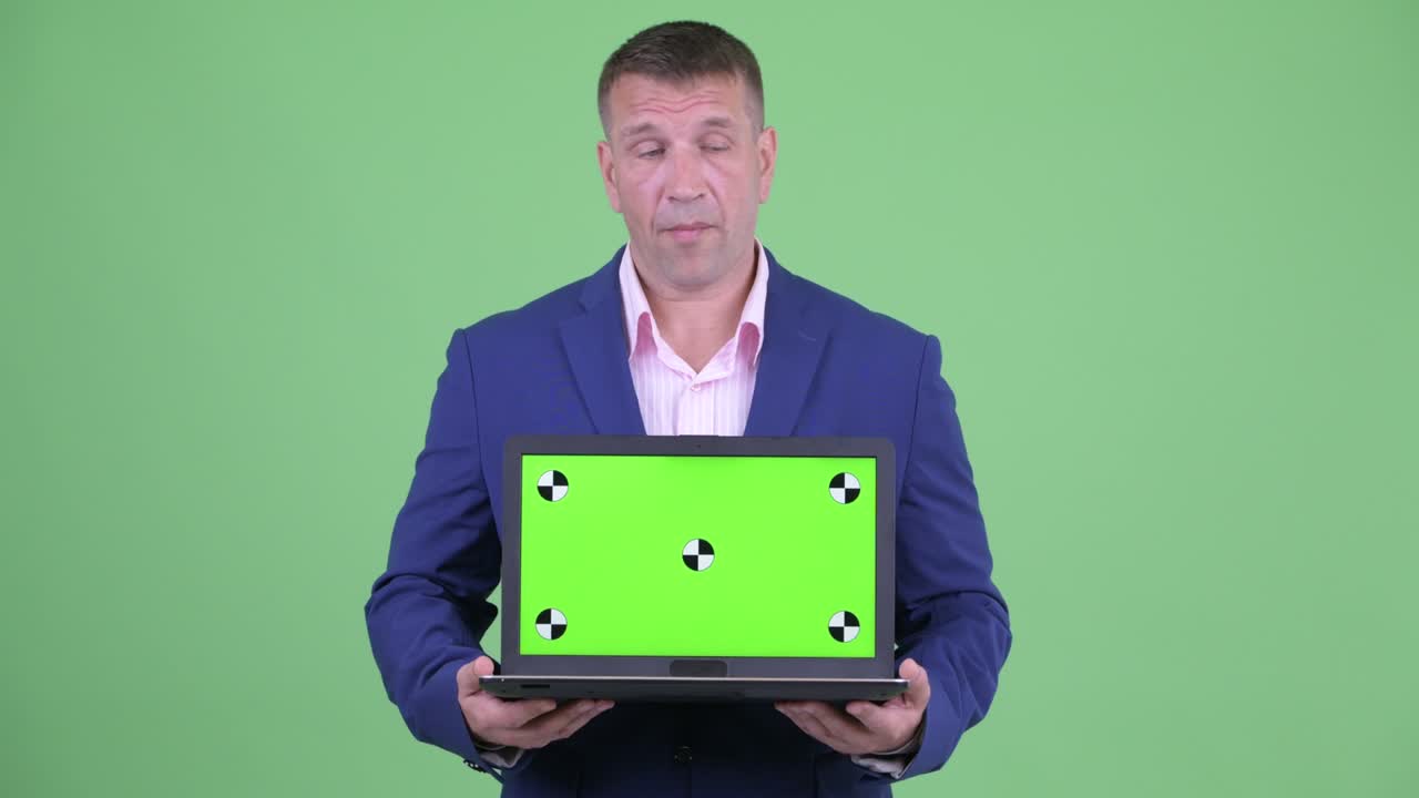 retrato de un musculoso y guapo hombre de negocios con traje contra el fondo verde del estudio