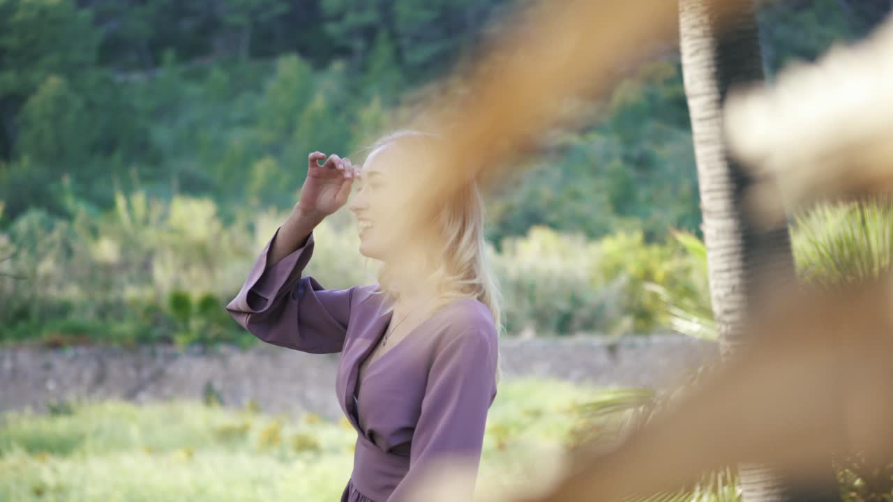 열대 정원에서 보라색 드레스를 입은 여자