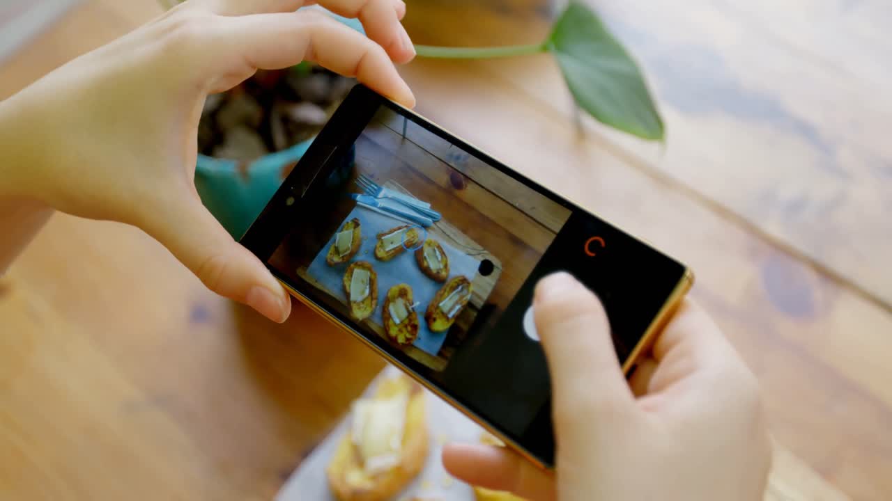 mujer fotografiando la bandeja de bocadillos con teléfono móvil 4k