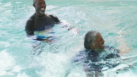 Video-Eines-Glücklichen-älteren-Afroamerikanischen-Paares,-Das-Im-Pool-Schwimmt