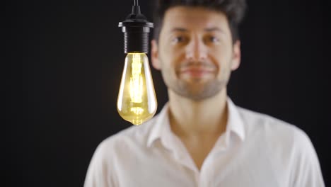 creative clever man finds new ideas symbolic idea lamp lights up.