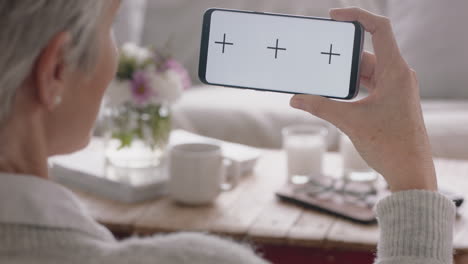 mujer madura teniendo video chat usando smartphone pantalla verde abuela charlando mirando a la llave croma disfrutando de la pantalla compuesta del teléfono móvil en orientación horizontal 4k metraje