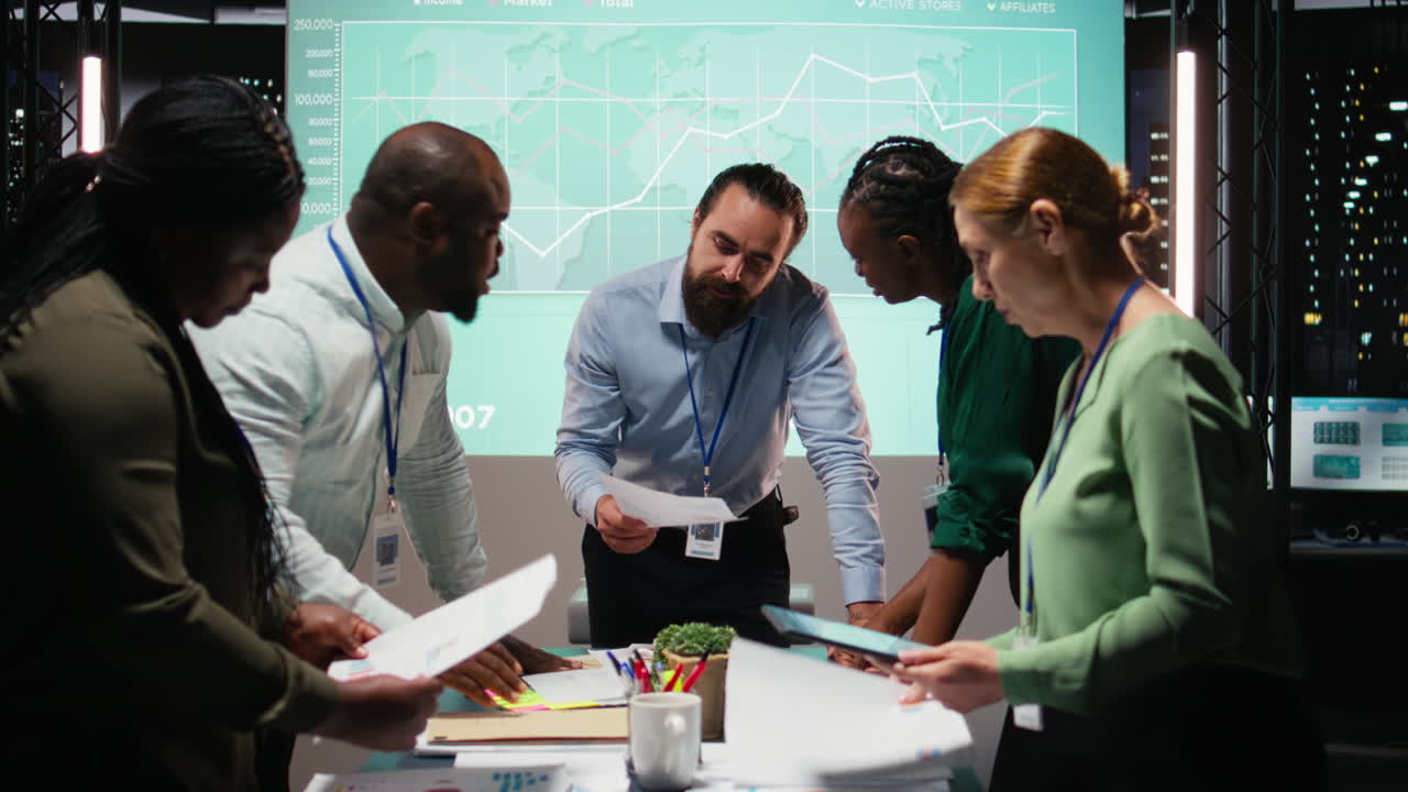 Diverse coworkers attend an after hours business meeting for analysis on files
