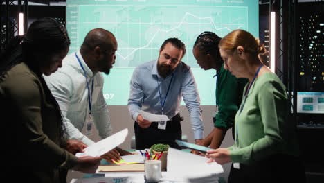diverse coworkers attend an after hours business meeting for analysis on files