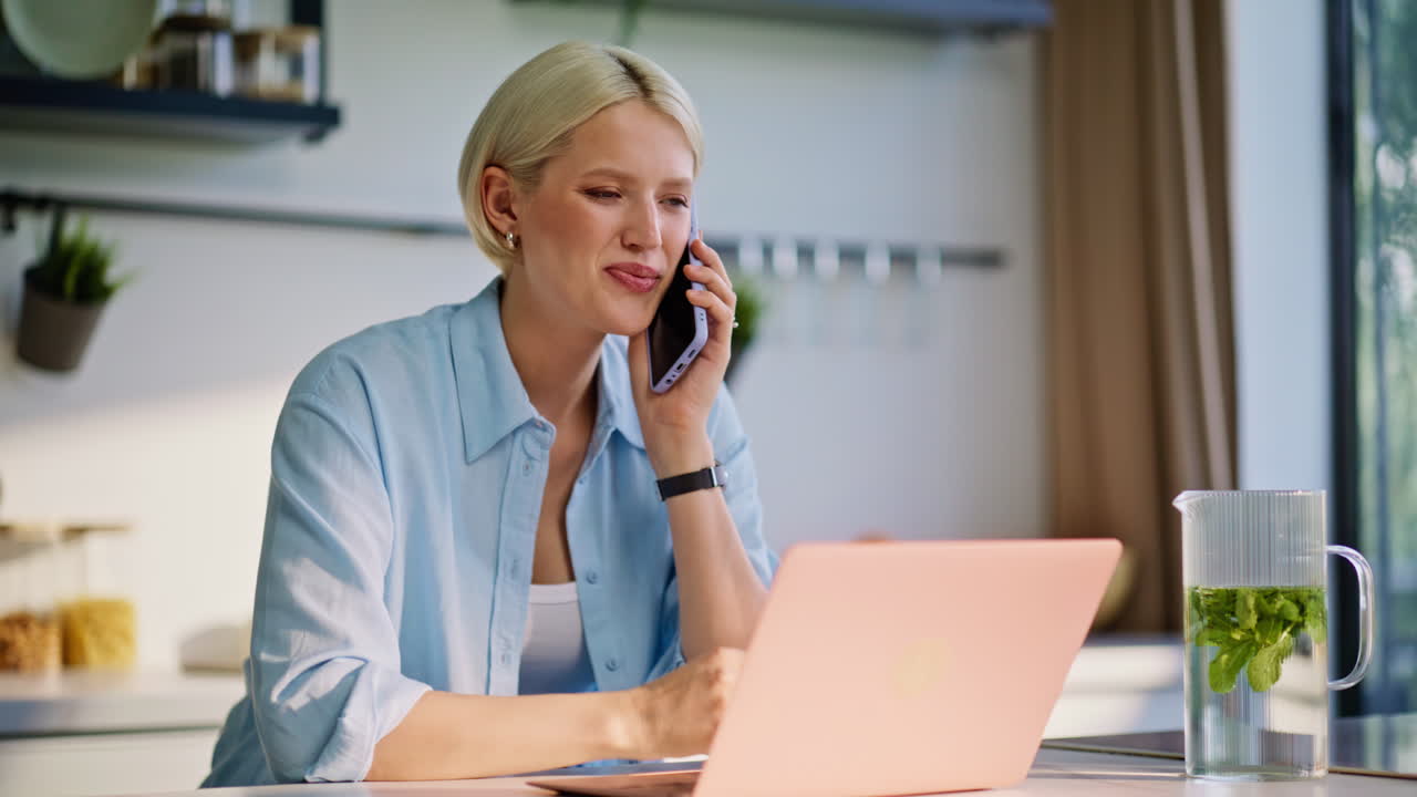 Nettbasert leder som svarer på anrop med smarttelefon og skriver på laptop hjemme, nærbilde