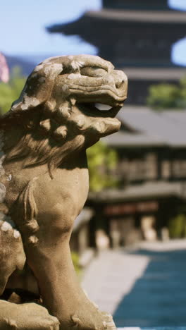 a stone lion statue in front of a japanese temple