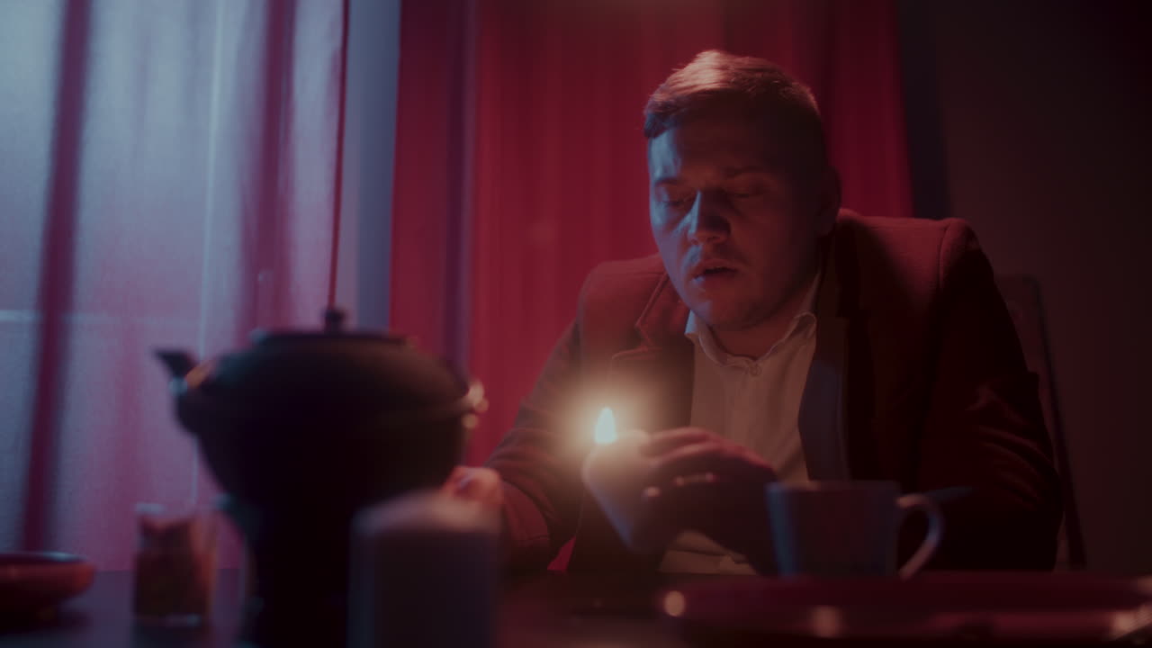 Man drinking tea in dimly lit room