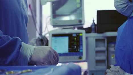 sección media de cirujanos multiétnicos realizando una operación en el teatro de operaciones en el hospital