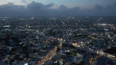 Fly-above-night-city,-hundreds-of-street-lights.-Aerial-panoramic-view-of-urban-neighbourhood-of-large-town.-Cancun,-Mexico