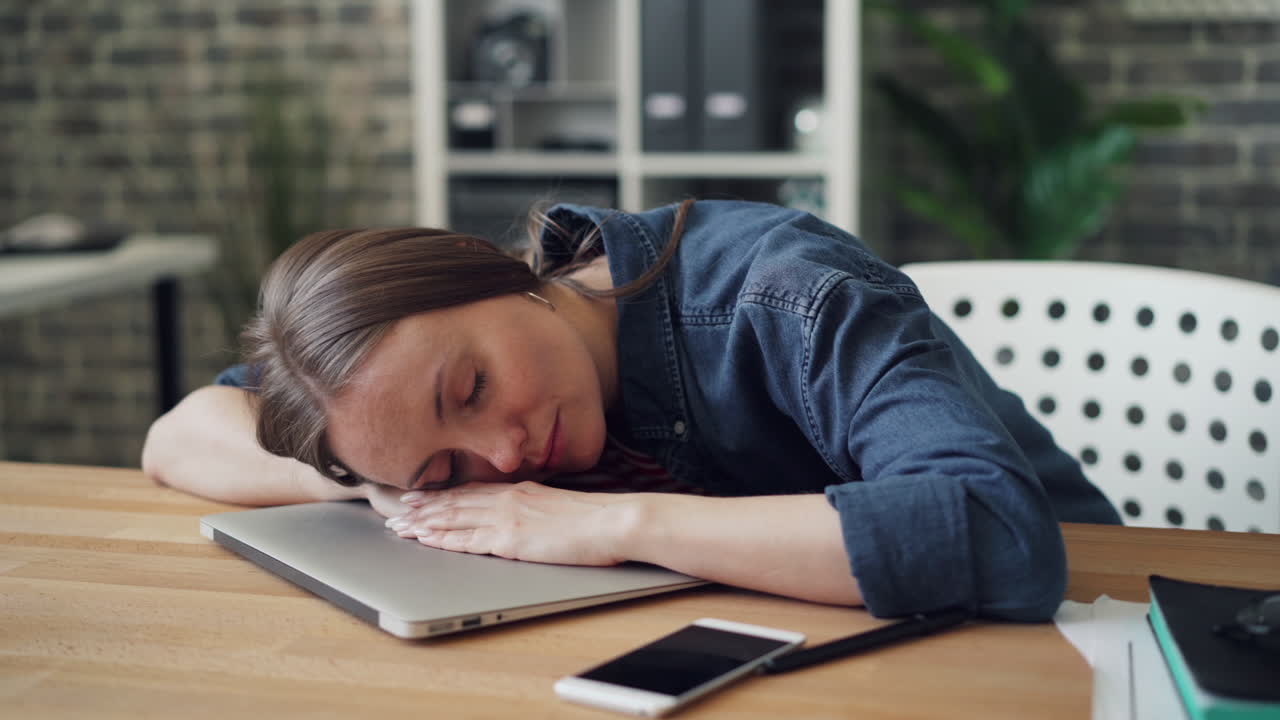 Woman sleeping at her desk
