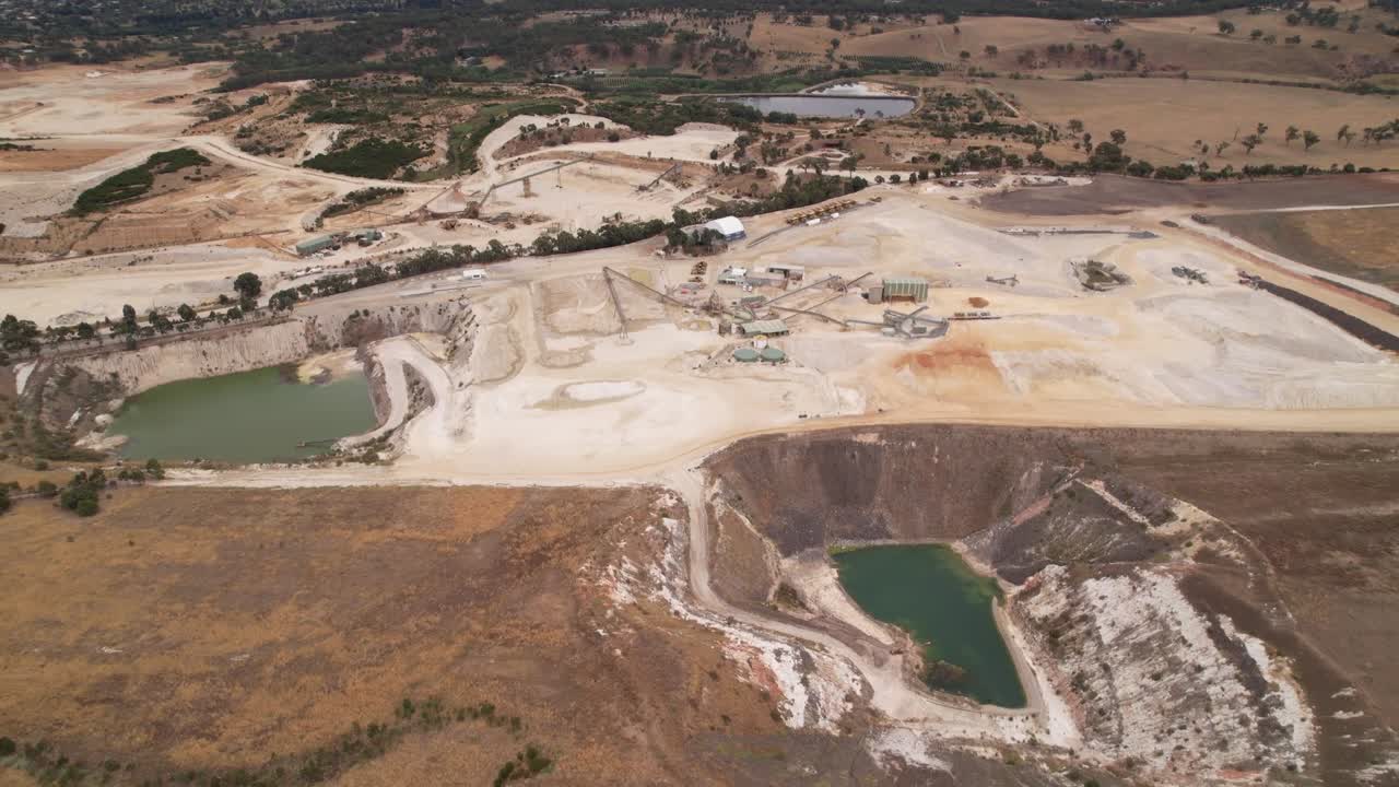 Stone open cut mine wide shot white earth and dams Victoria, Australia