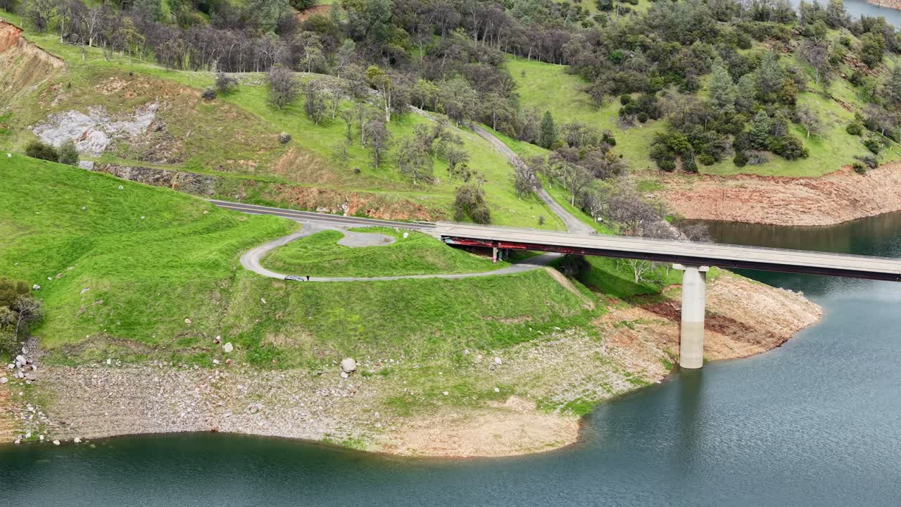Aerial footage sweeps over the Don Pedro Reservoir Bridge. Shot on a DJI Air 3S.