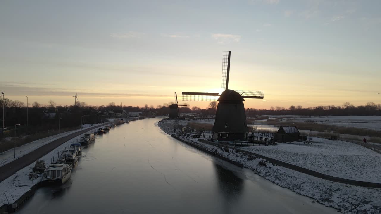 Veduta aerea del tradizionale mulino a vento Strijkmolen all'alba invernale ad Alkmaar, Paesi Bassi, con splendida illuminazione all'alba, atmosfera calma, filmato drone di alta qualità che cattura momenti sereni