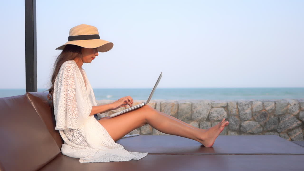 Woman working on laptop at beach