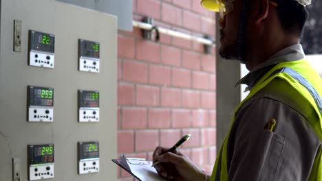 ingeniero asiático trabajando en la sala de calderas.