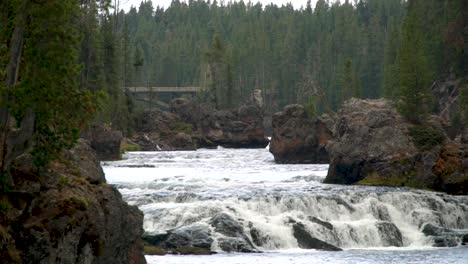 white water and a view of the bridge above the upper falls in grand canyon of yellowstone national park