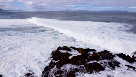 slomo aerial view as tumultuous atlantic ocean waves crash onto rocky shore