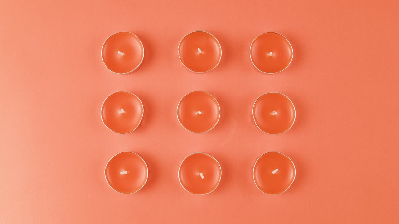 Orange Tea Light Candles on Coral Background