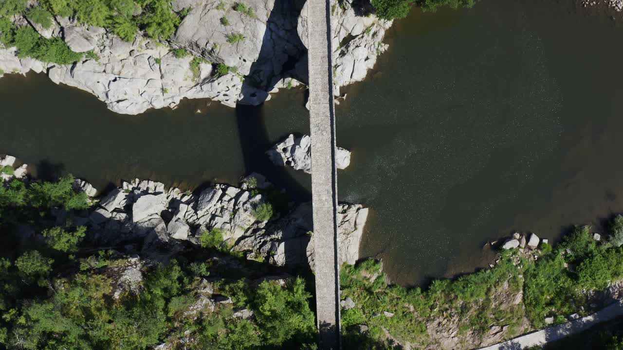 Overhead drone shot of the length of the Devil's Bridge and Arda River located in the town of Ardino near the Rhodope Mountains in Bulgaria
