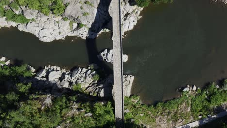 Overhead drone shot of the length of the Devil&#039;s Bridge and Arda River located in the town of Ardino near the Rhodope Mountains in Bulgaria
