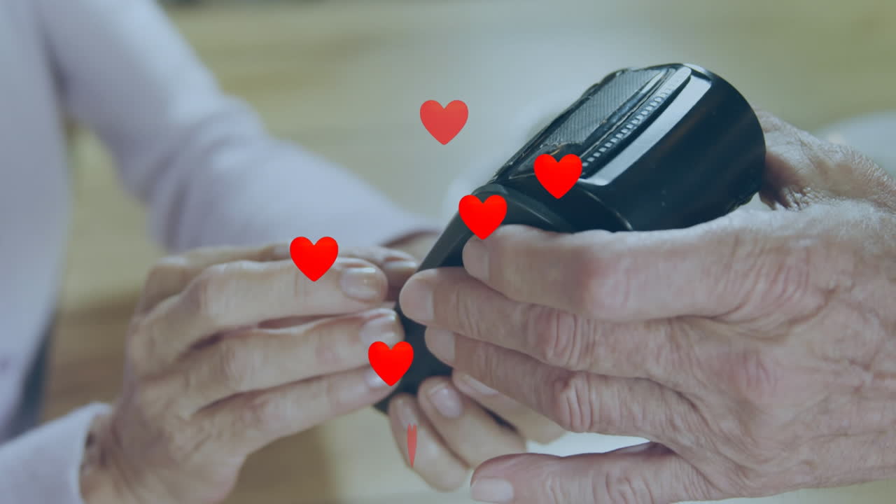 결제 터미널을 사용하는 사람들 위에 떨어지는 심장의 애니메이션