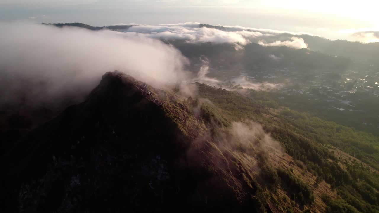 인도네시아 발리에서 해가 뜨는 동안 바투르 산 꼭대기 위의 풍경적인 구름