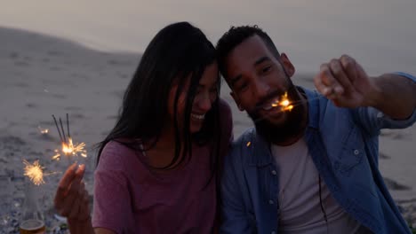 Feliz-Pareja-Joven-De-Raza-Mixta-Divirtiéndose-Con-Bengalas-En-La-Playa-4k