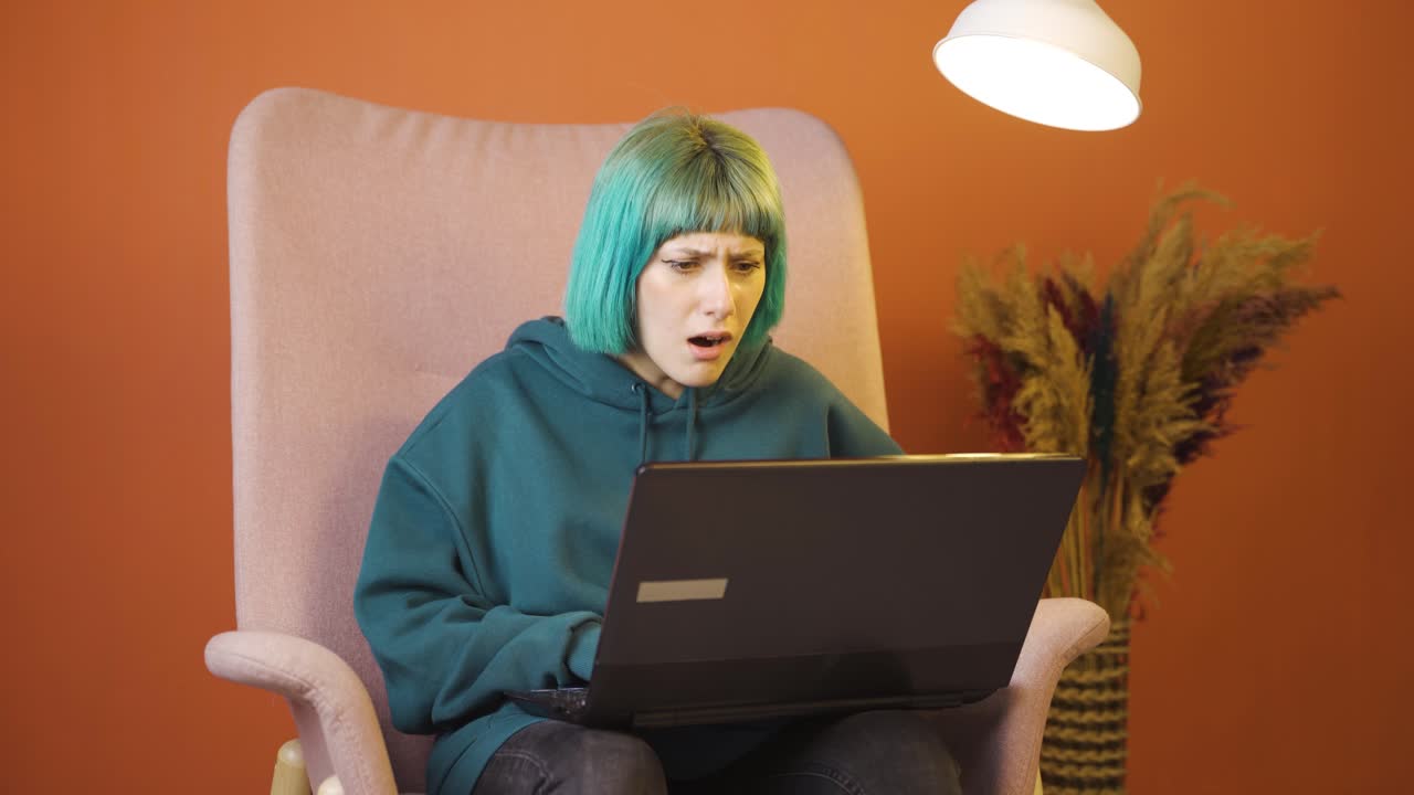 la mujer joven que mira la computadora portátil se frustra.