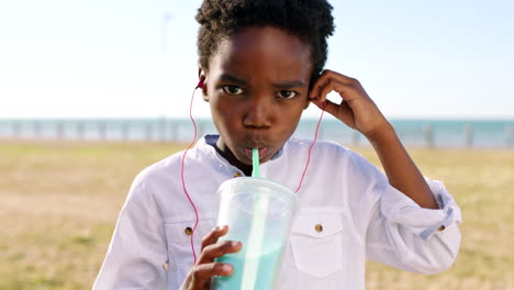 Child,-earphones-and-drinking-milkshake-outside