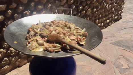 sizzling chicken stir-fry in an enormous wok, with large wooden spoon