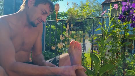 on a sunny summer day in bern, switzerland, a man carefully tends to his girlfriend’s foot with a callus file on a leafy balcony, a quiet, intimate glimpse into daily couple life